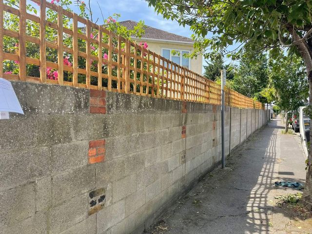 Timber trellis topping fitted along a boundary wall