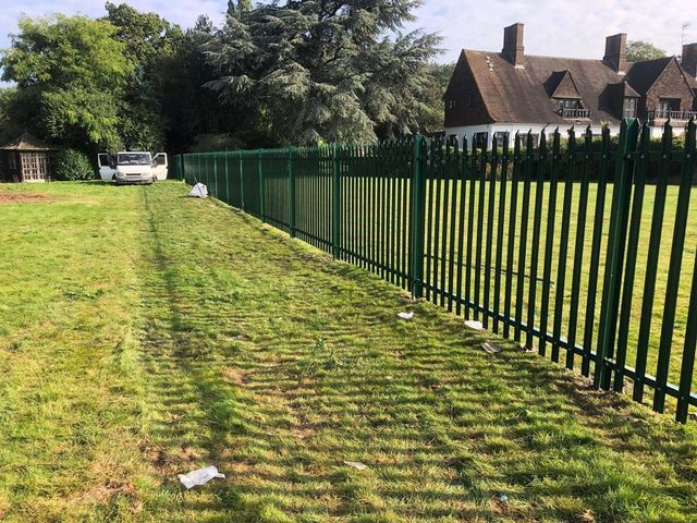 Green metal railings installed along a field boundary